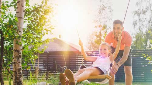 father and daughter swinging