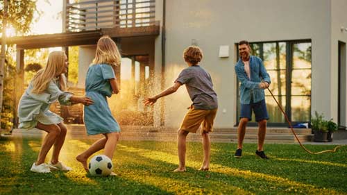 family playing soccer in yard